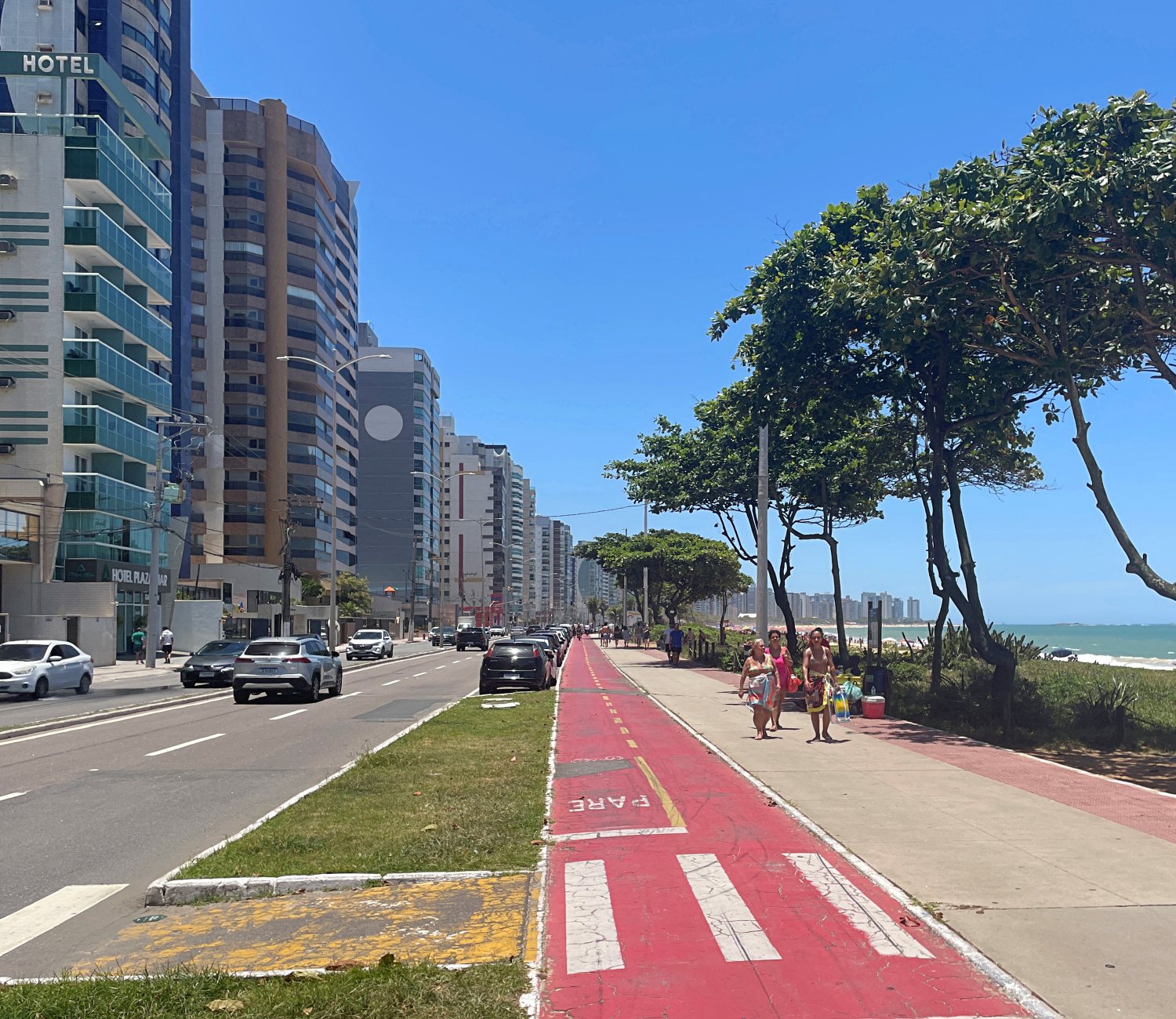 Avenida movimentada da Grande Vitória, com carros em circulação durante o dia